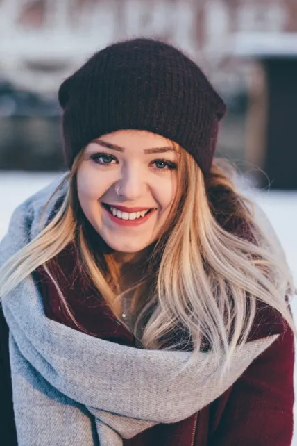 Smiling woman in a winter hat and scarf