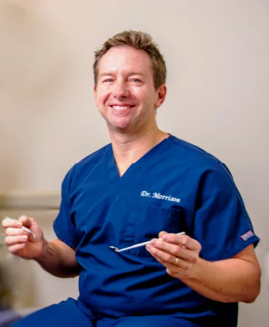 Dr. Stephen Morrison smiling in navy scrubs