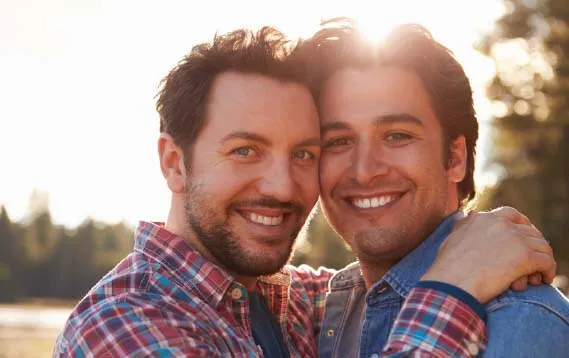 Two men smiling in warm evening light