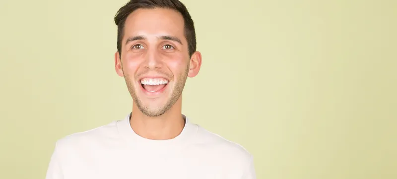 Man laughing against a yellow wall